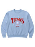 A light blue crewneck sweatshirt featuring a red and white graphic print on the front that reads 'TITANS NASHVILLE, TN' with a circular logo, displayed on a neutral light gray background.
