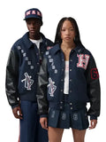 Two models wearing matching navy blue varsity jackets with black leather sleeves, featuring 'HARVARD' lettering and sports graphics, posed against a solid gray background.