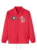 A red Coach jacket featuring the Georgia Bulldogs logo on the left chest and the iconic Coach owl logo on the right chest, displayed against a neutral gray background.