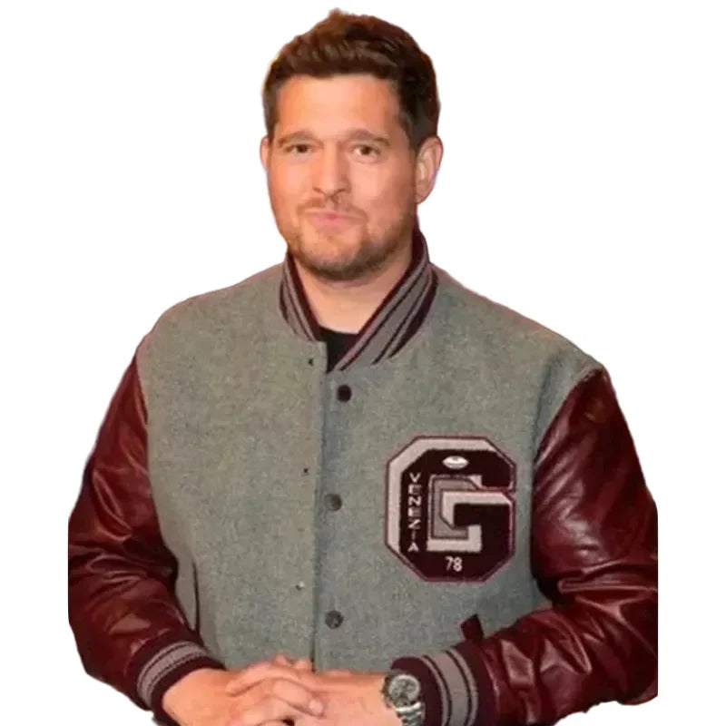 A man wearing a gray and burgundy varsity jacket with a large 'G' and 'OKLAHOTA 78' patch on the chest, posed against a dark studio background with blue lighting.