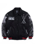 A black varsity-style bomber jacket with black leather sleeves, featuring white graphic prints and text on the front and sleeves, red and black striped ribbed cuffs and hem, and snap-button closure.